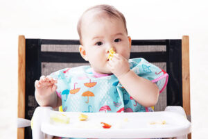 手づかみ食べをする赤ちゃんの写真