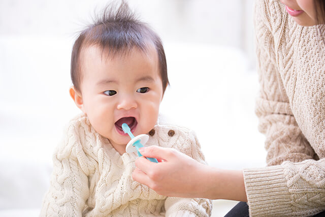 歯磨きをする赤ちゃんとお母さんの手