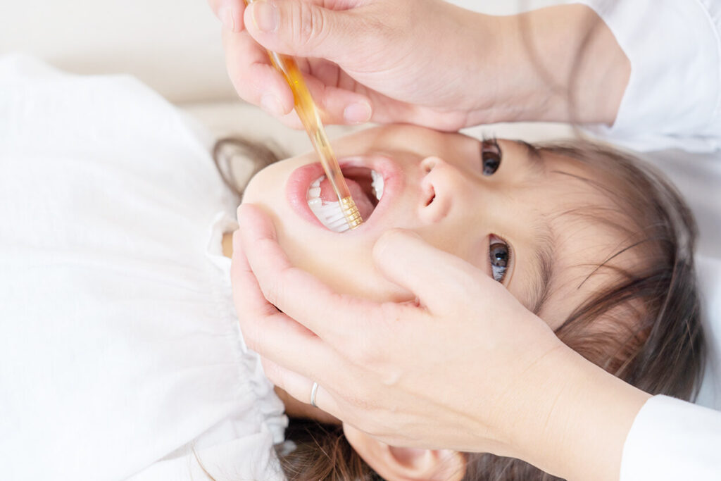 歯磨きをしてもらう少女